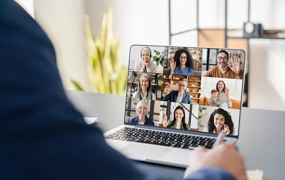A speaker presenting at a webinar with participants on screen